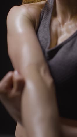 Vertical-Video-Close-Up-Studio-Shot-Showing-Chest-And-Abdomen-Of-Mature-Woman-Wearing-Gym-Fitness-Clothing-Doing-Stretching-Exercises